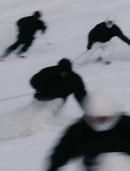 Blurred skiers in black