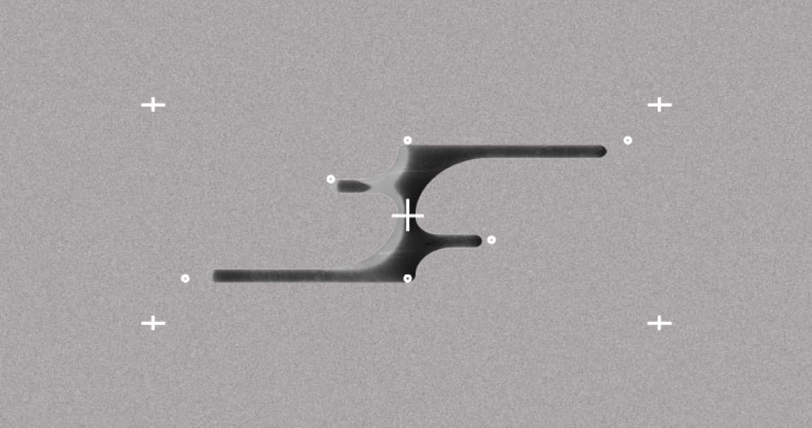 A flat grey noise field with crop marks and a black abstract shape