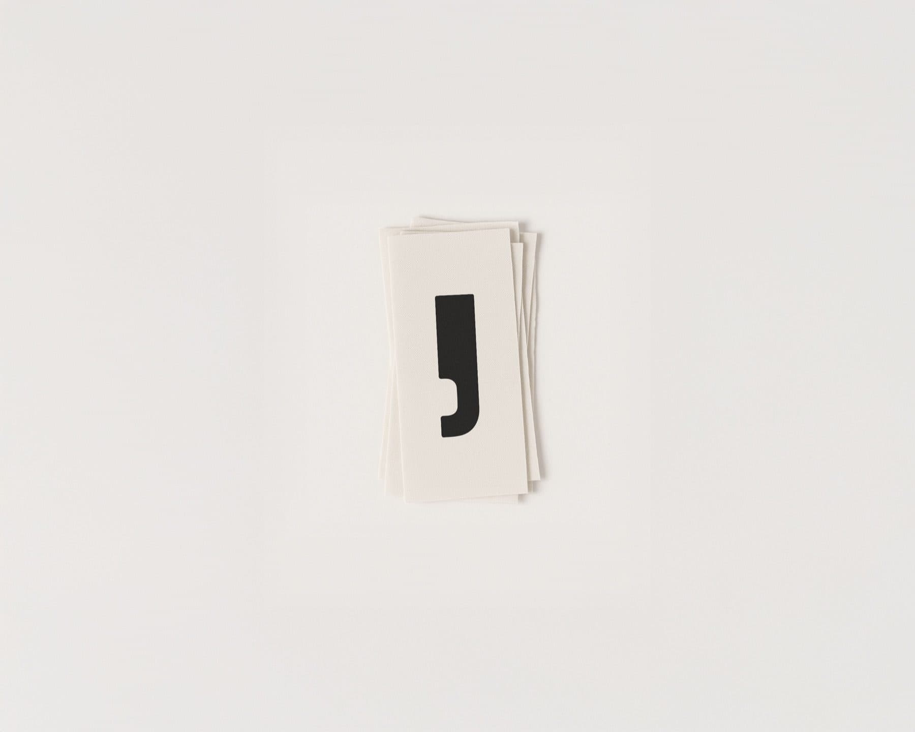 A stack of small white cards printed with a black comma-shaped mark.