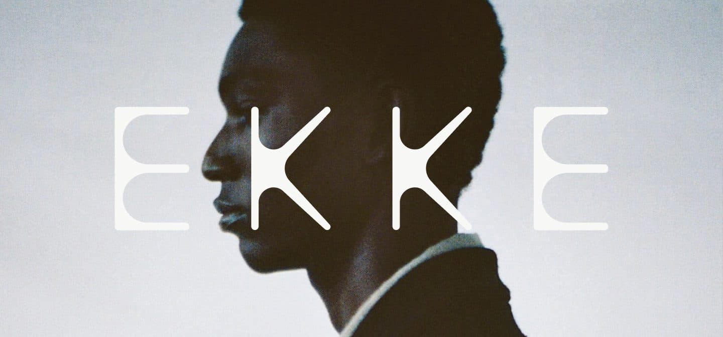 The letters EKKE in pale type, split by the dark profile of a man's head against a pale grey wall.