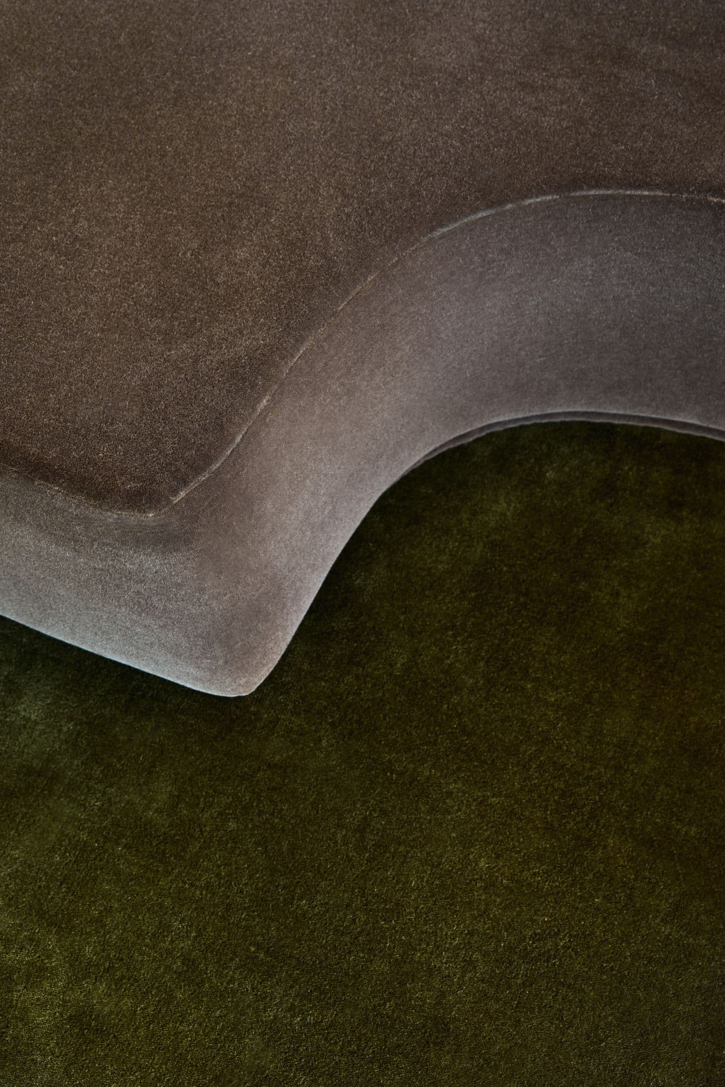 A brown velvet curve over a dark green floor.