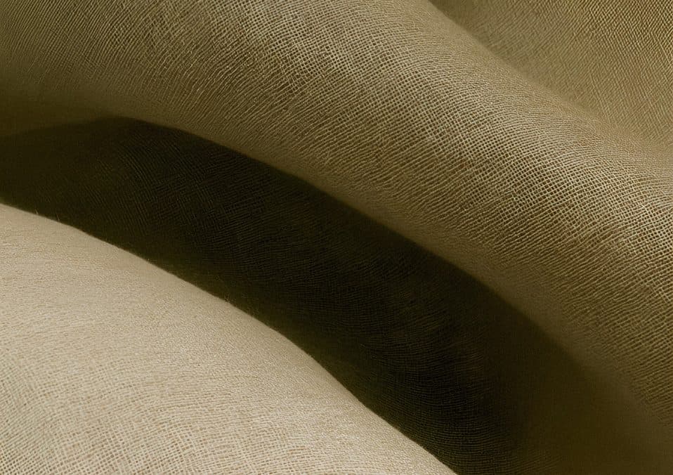 Soft folds of olive-green linen in warm light.