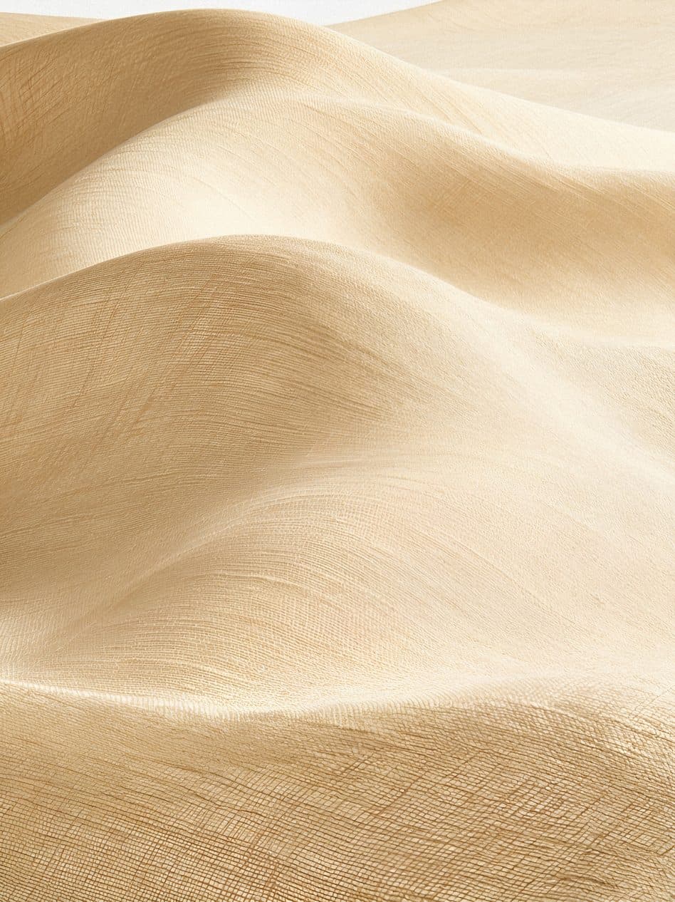 Soft folds of pale, finely woven linen in warm light.