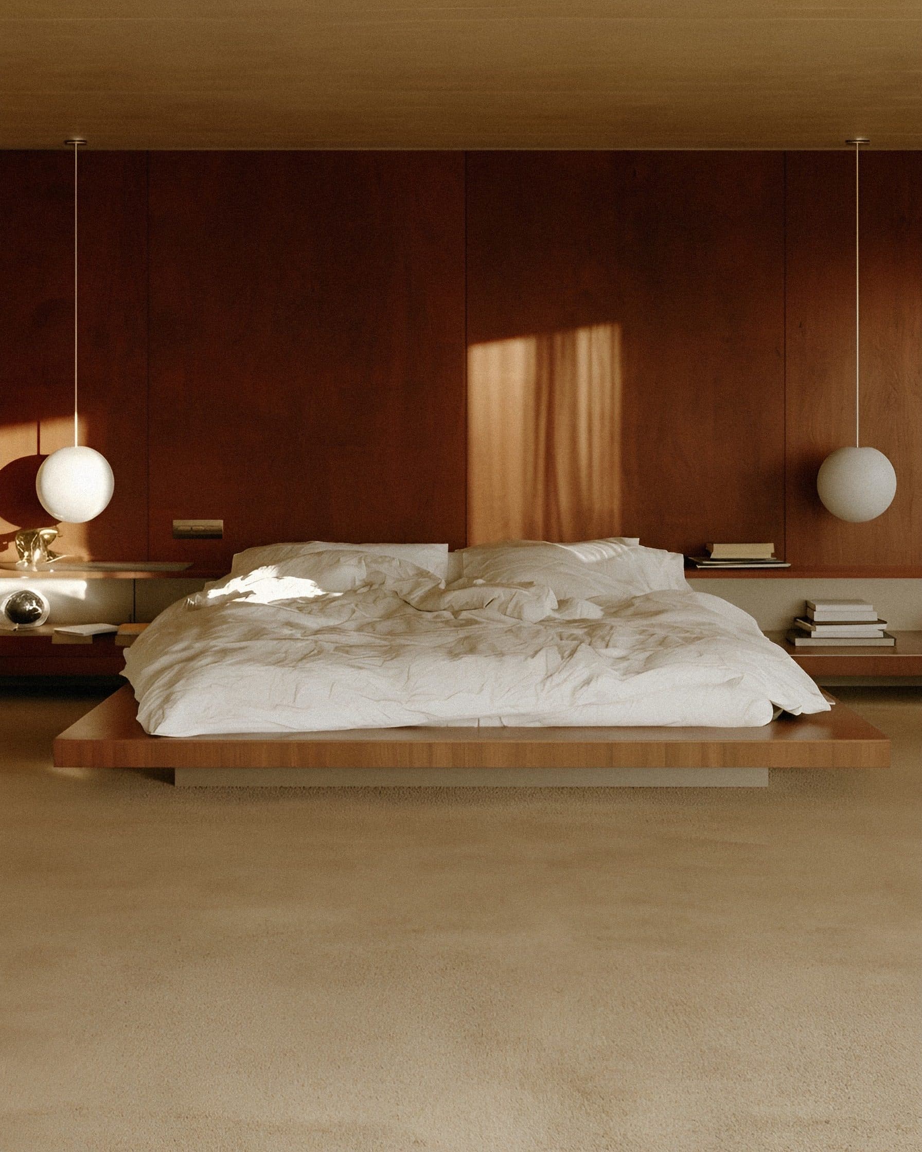 A low platform bed with white linen in a timber-panelled room, with a round pendant lamp hanging on each side under a warm ceiling.