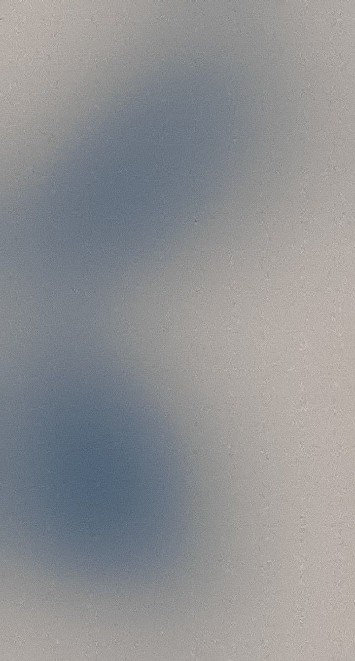 A soft blue-grey gradient over a beige, finely textured surface.