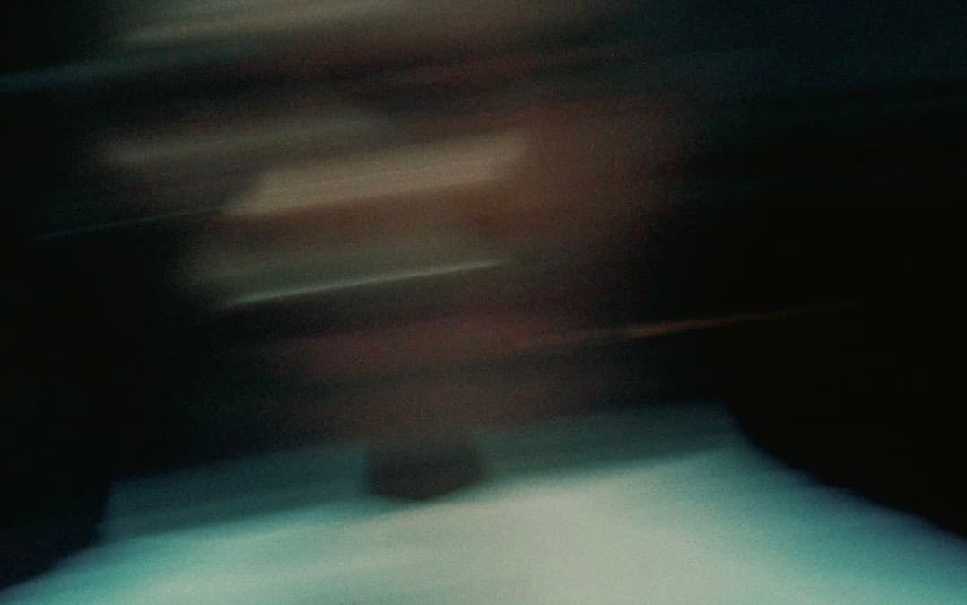 A blurred, dark teal and brown moving collage of identities, sites, campaigns and objects
